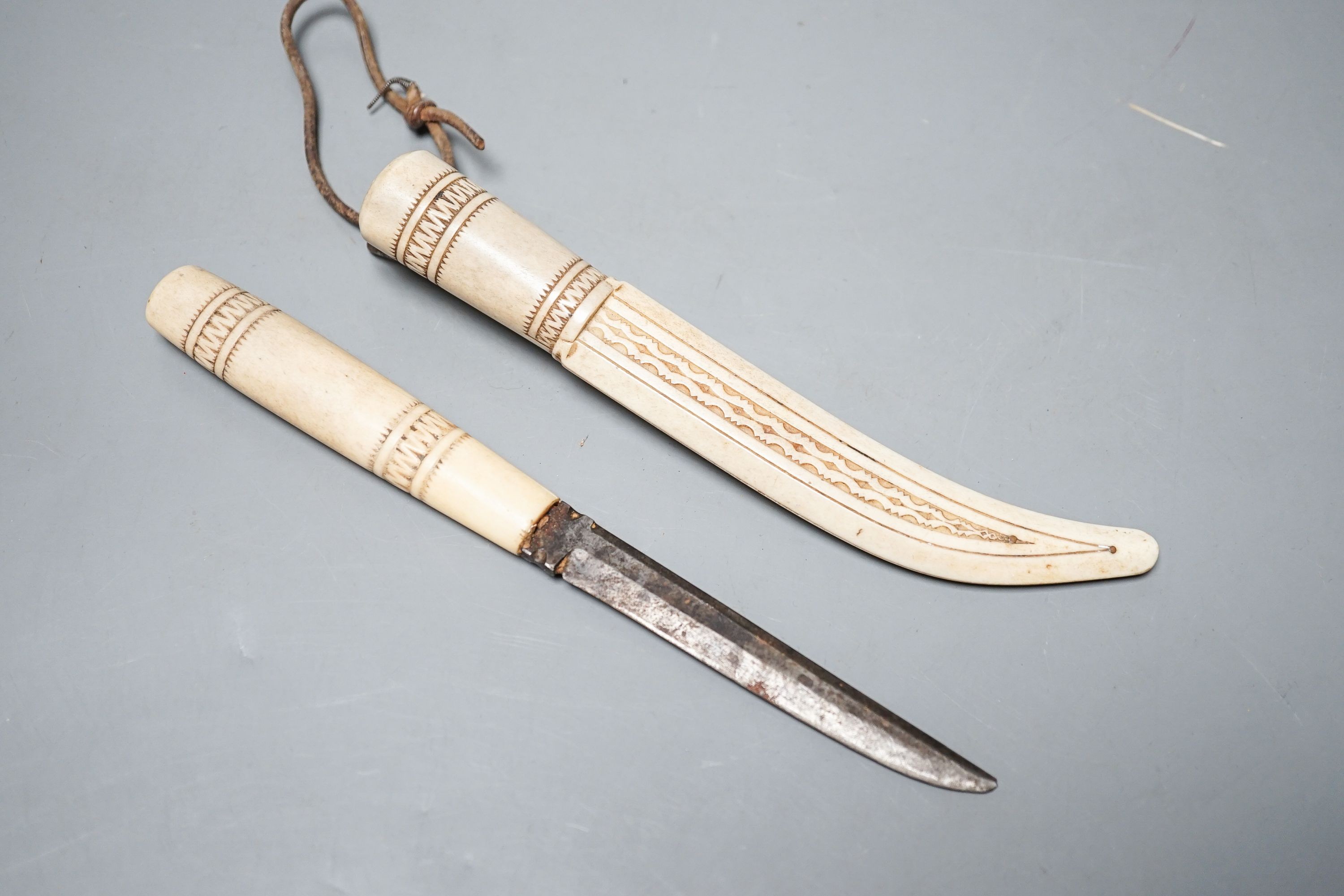 A 19th century Inuit carved stag antler dagger and scabbard, initialled ‘K.E’.